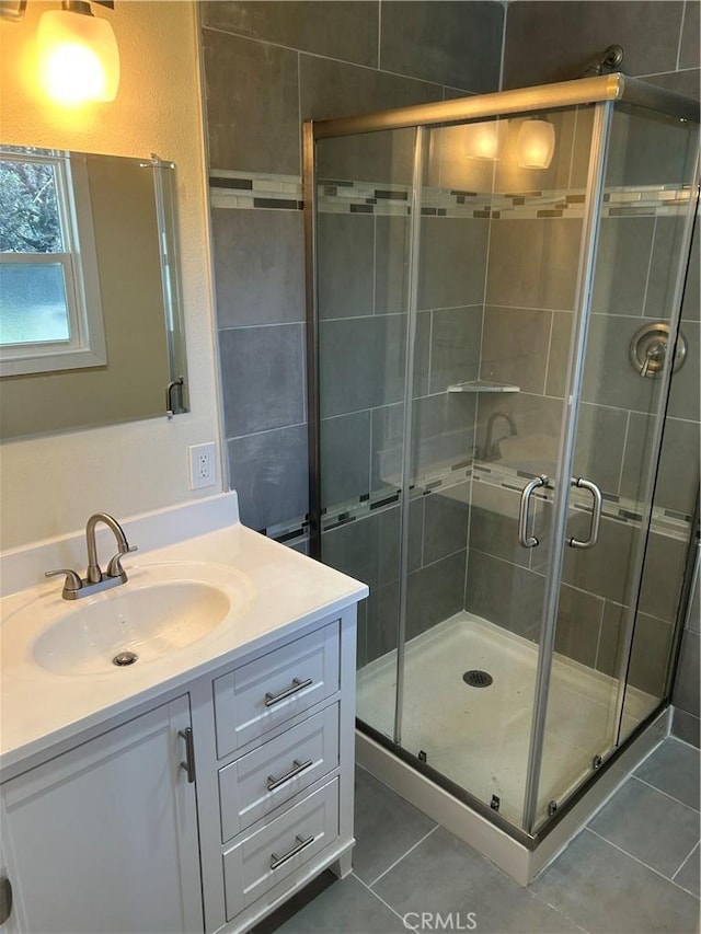 bathroom featuring walk in shower, vanity, and tile patterned flooring