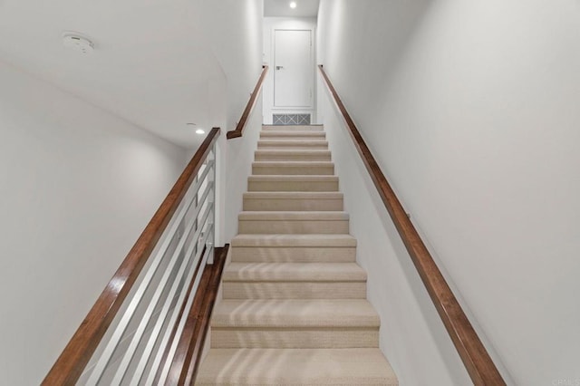 staircase featuring carpet