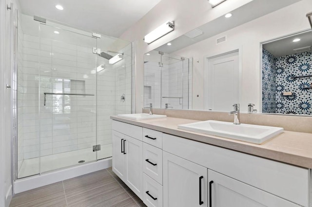 bathroom with vanity and a shower with door