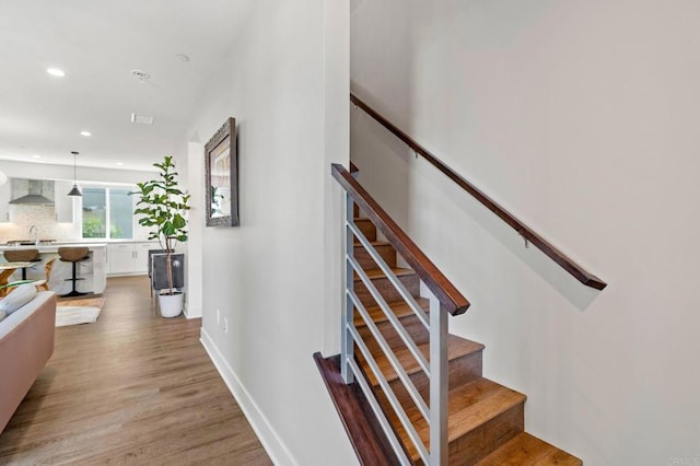 stairway featuring sink and wood-type flooring