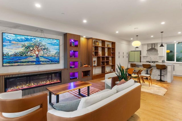 living room with light hardwood / wood-style floors and sink