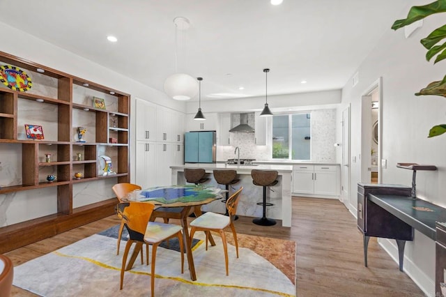 dining space with sink and light hardwood / wood-style floors