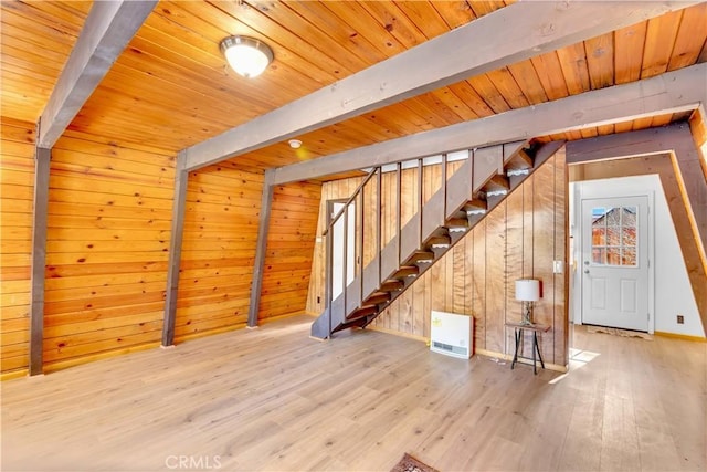 interior space featuring beam ceiling, hardwood / wood-style flooring, and wooden walls