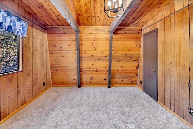 carpeted empty room with wood ceiling and wood walls