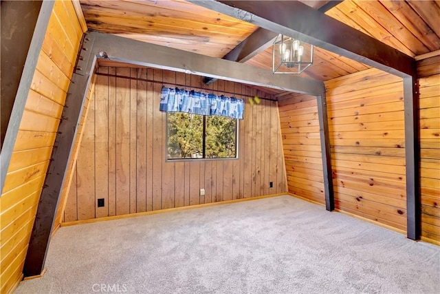 carpeted empty room with vaulted ceiling with beams and wood walls