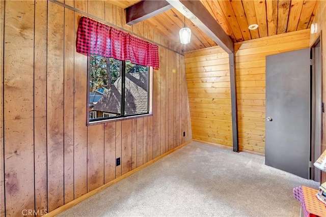 carpeted spare room featuring wood ceiling, beam ceiling, and wooden walls