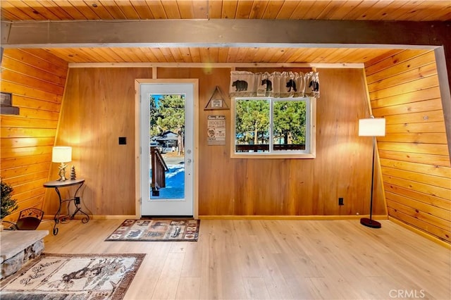 entryway featuring hardwood / wood-style floors, wooden walls, and beamed ceiling