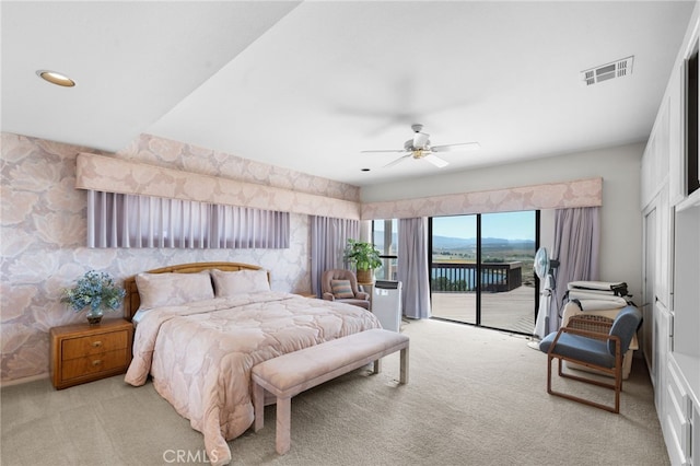 bedroom with light carpet, ceiling fan, a water view, and access to outside