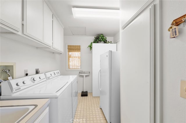 clothes washing area featuring cabinets and independent washer and dryer