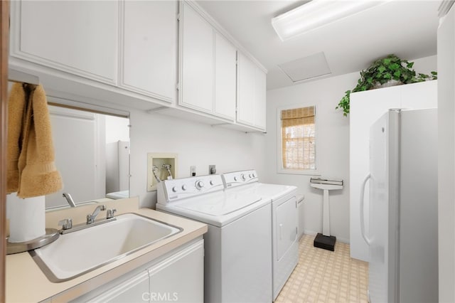 washroom with cabinets, washing machine and clothes dryer, and sink