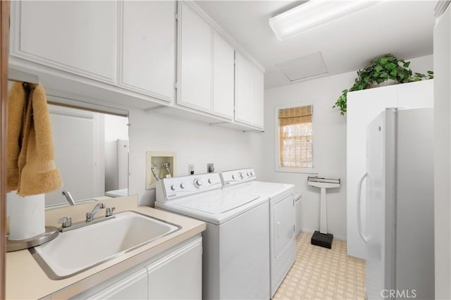 washroom with cabinets, sink, and washer and clothes dryer