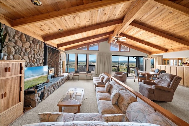 living room featuring carpet floors, beam ceiling, ceiling fan, and a wood stove