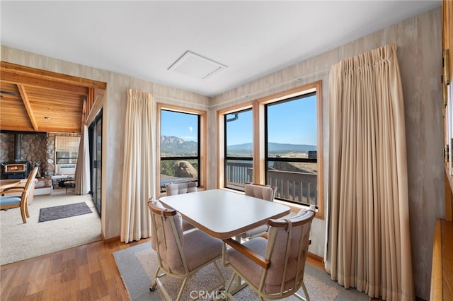 dining space with wood-type flooring, a mountain view, and a wood stove