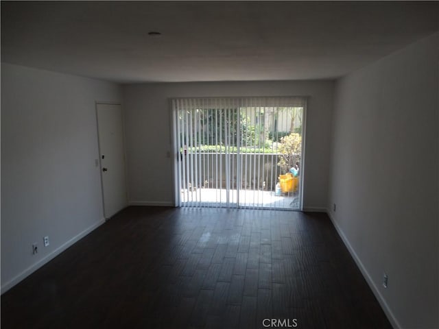 spare room with dark wood-type flooring