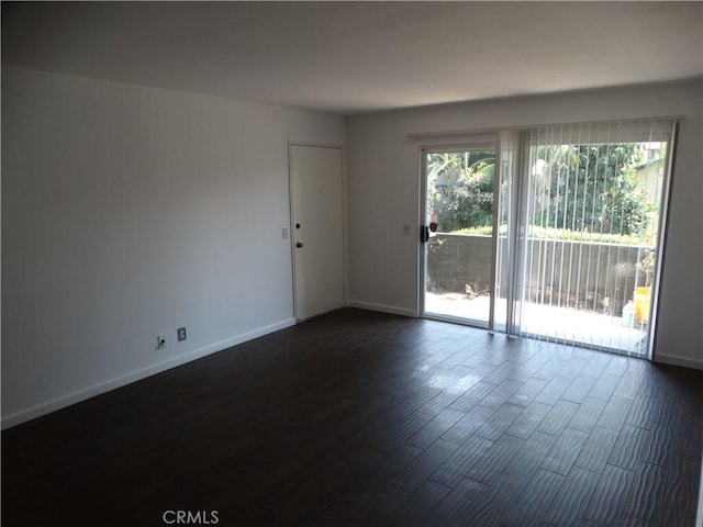 empty room with dark hardwood / wood-style flooring