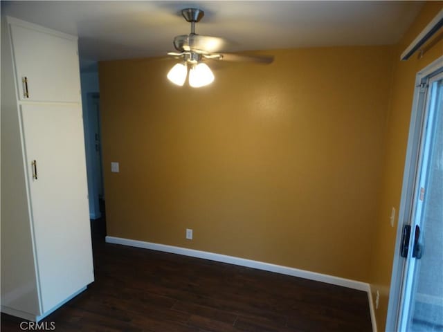 spare room featuring ceiling fan and dark wood-type flooring