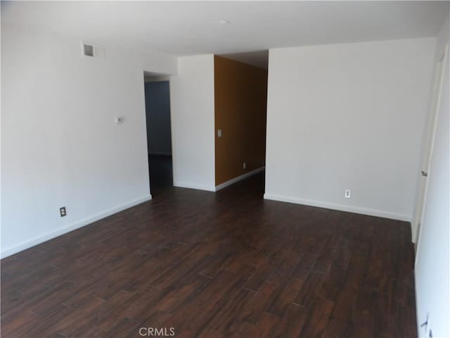 unfurnished room with dark wood-type flooring