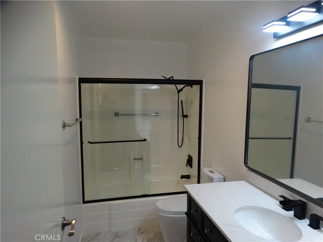 full bathroom featuring vanity, toilet, and shower / bath combination with glass door