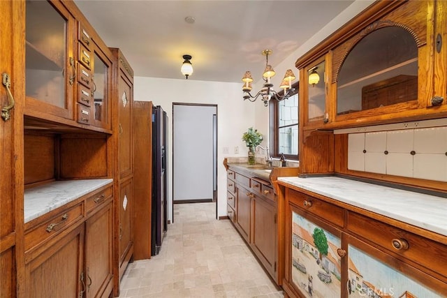 kitchen with stainless steel dishwasher, sink, hanging light fixtures, and a chandelier