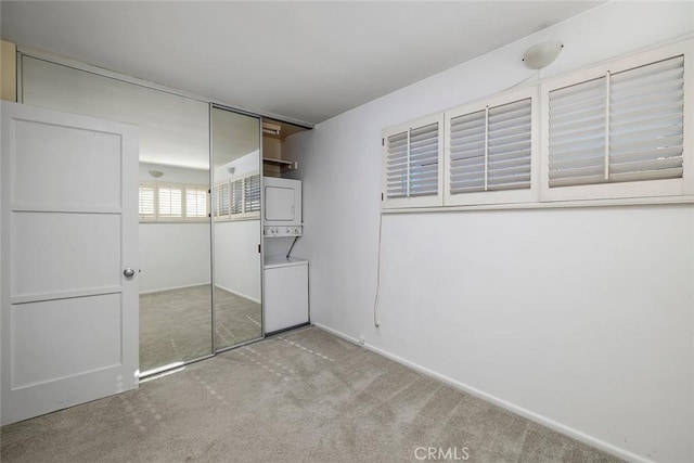 115 Apolena Ave, Newport Beach, CA 92662 - unfurnished bedroom featuring stacked washer / dryer, carpet flooring, a closet, and baseboards