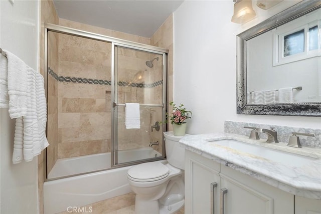 full bathroom featuring vanity, toilet, and bath / shower combo with glass door