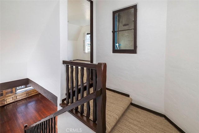 stairway featuring hardwood / wood-style flooring and vaulted ceiling