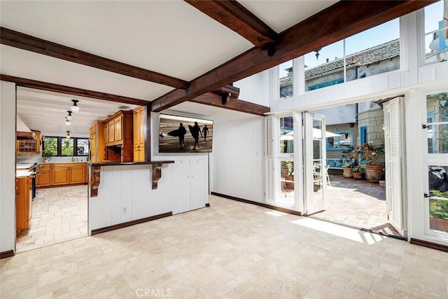 unfurnished living room with beamed ceiling