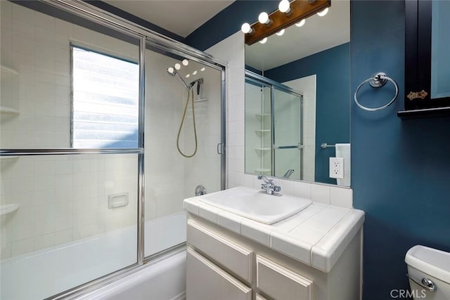 full bathroom with shower / bath combination with glass door, vanity, and toilet