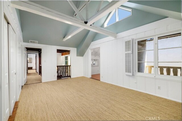 interior space featuring light carpet, beam ceiling, and high vaulted ceiling