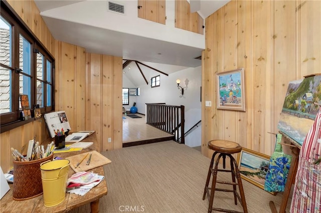 115 Apolena Ave, Newport Beach, CA 92662 - living area featuring an upstairs landing, wooden walls, lofted ceiling, and carpet flooring