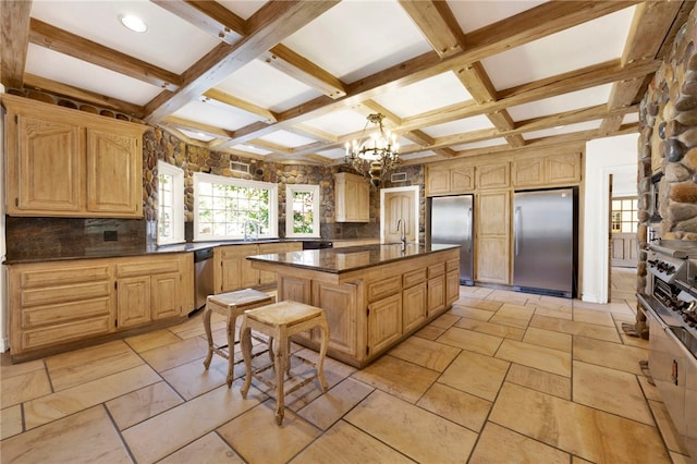 kitchen featuring a kitchen island, coffered ceiling, stainless steel appliances, a breakfast bar, and an inviting chandelier