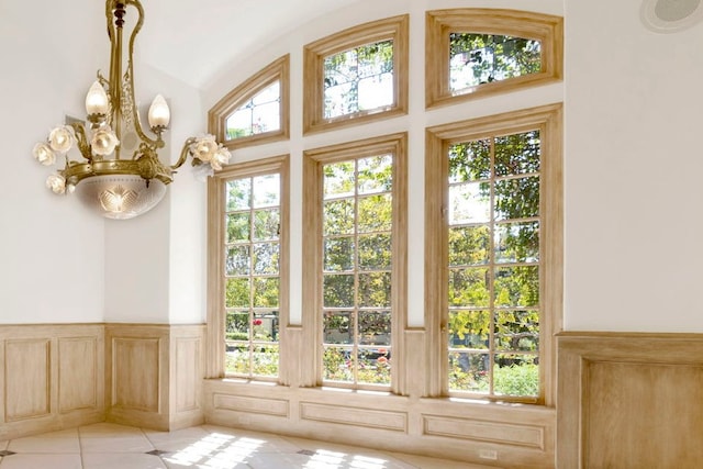 doorway to outside featuring a notable chandelier, light tile patterned floors, and a healthy amount of sunlight