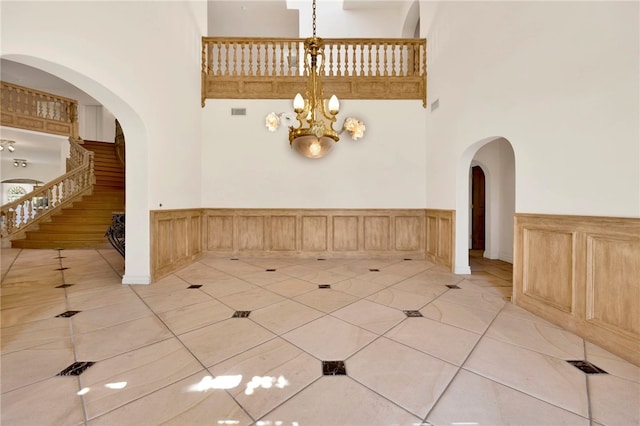 tiled foyer entrance featuring an inviting chandelier and a high ceiling