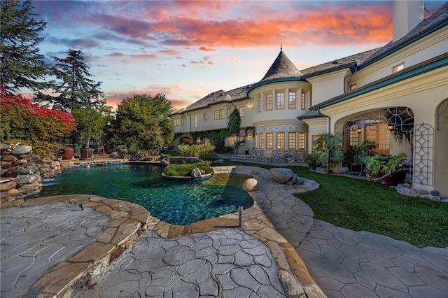 pool at dusk with a patio