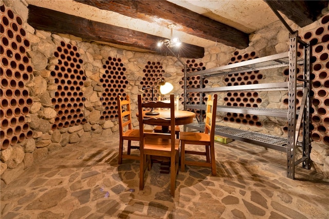 wine cellar with a notable chandelier and beam ceiling