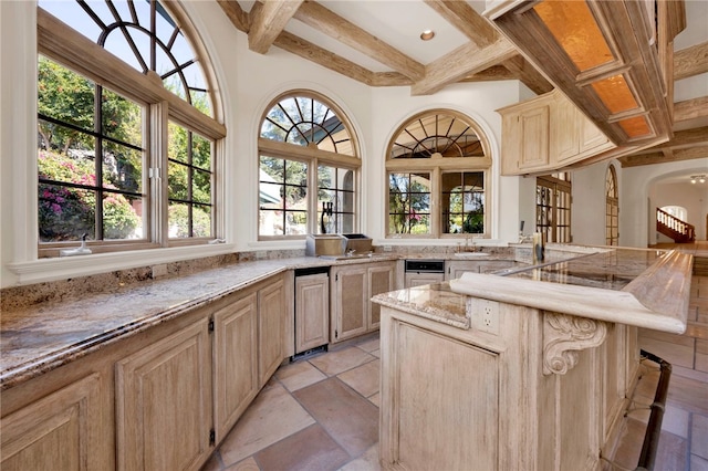 kitchen with light stone countertops, beamed ceiling, and light brown cabinetry