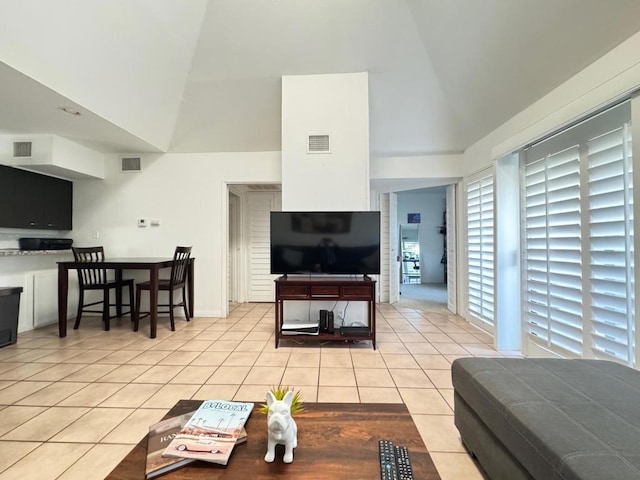 living room with light tile patterned floors and high vaulted ceiling