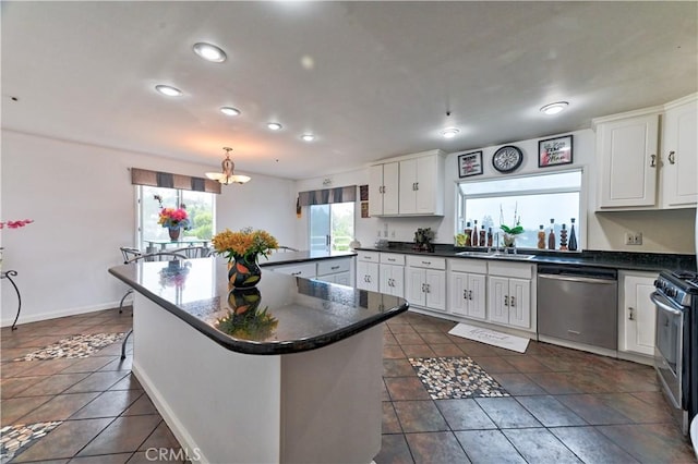 kitchen with sink, white cabinets, stainless steel appliances, and a notable chandelier