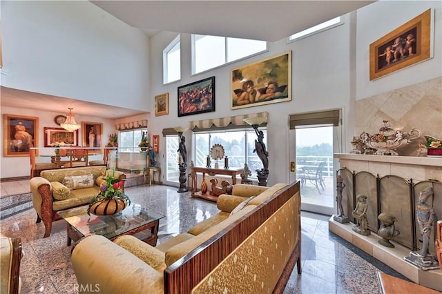 living room with a fireplace and a towering ceiling