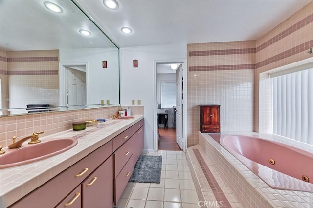 bathroom with tiled bath, tile patterned floors, and vanity