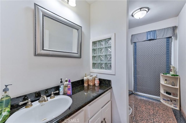 bathroom with walk in shower and vanity