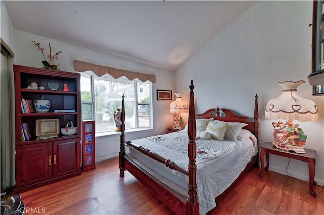 bedroom featuring hardwood / wood-style flooring and vaulted ceiling