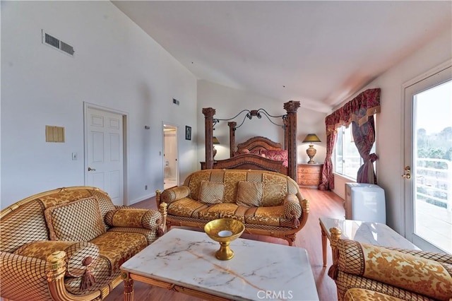 bedroom with access to outside, light wood-type flooring, and high vaulted ceiling