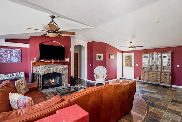 living room with a fireplace, vaulted ceiling, and ceiling fan