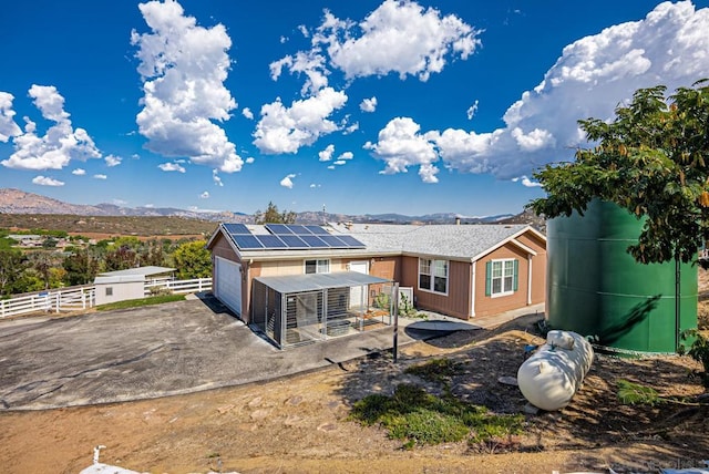 back of house with a mountain view, a patio area, and solar panels