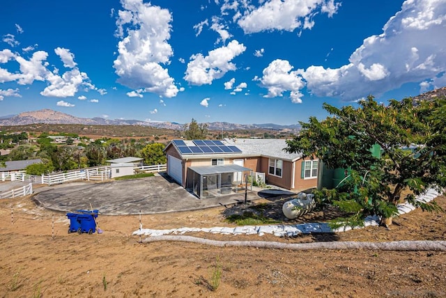 rear view of property featuring solar panels and a mountain view