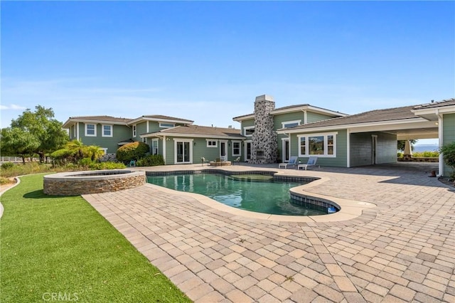 view of swimming pool with an in ground hot tub, a patio area, and a lawn