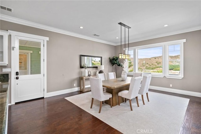 dining room featuring visible vents, baseboards, dark wood-style floors, and ornamental molding