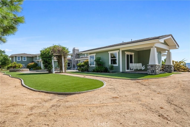 rear view of house featuring a yard