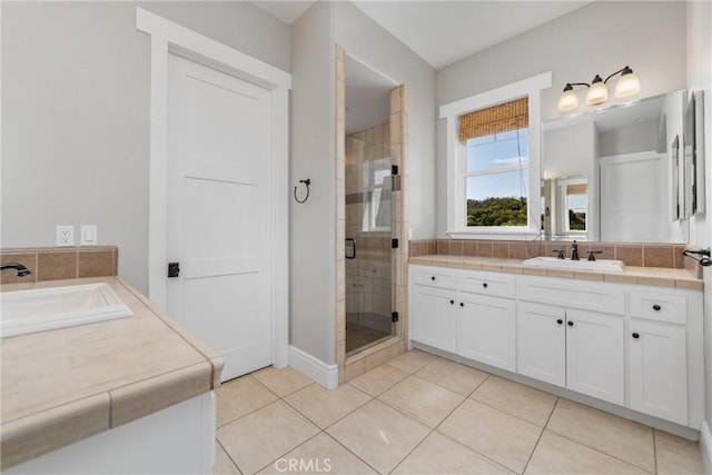 bathroom with tile patterned flooring, a shower stall, two vanities, and a sink